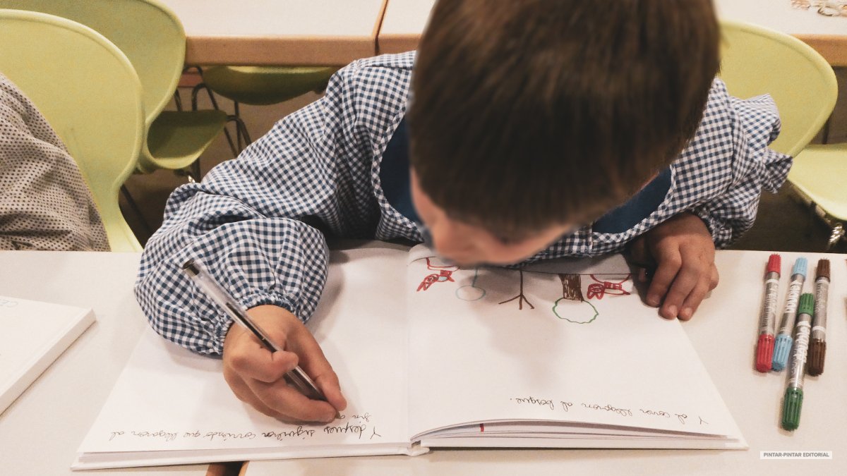 Niño dibujando y escribiendo durante una actividad creativa