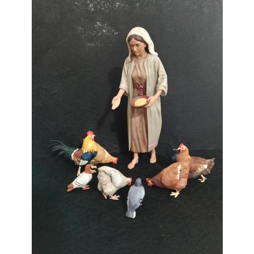 Mujer dando de comer a las gallinas [3]