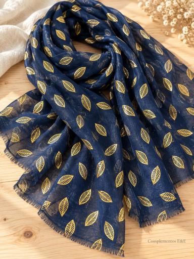 Pañuelo azul marino con estampado de hojas doradas y acabado con flecos