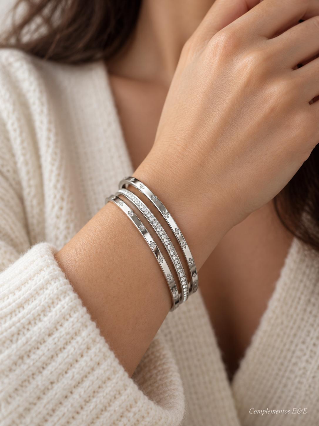Set de tres pulseras de aro de acero plateado con una pulsera central de brillos