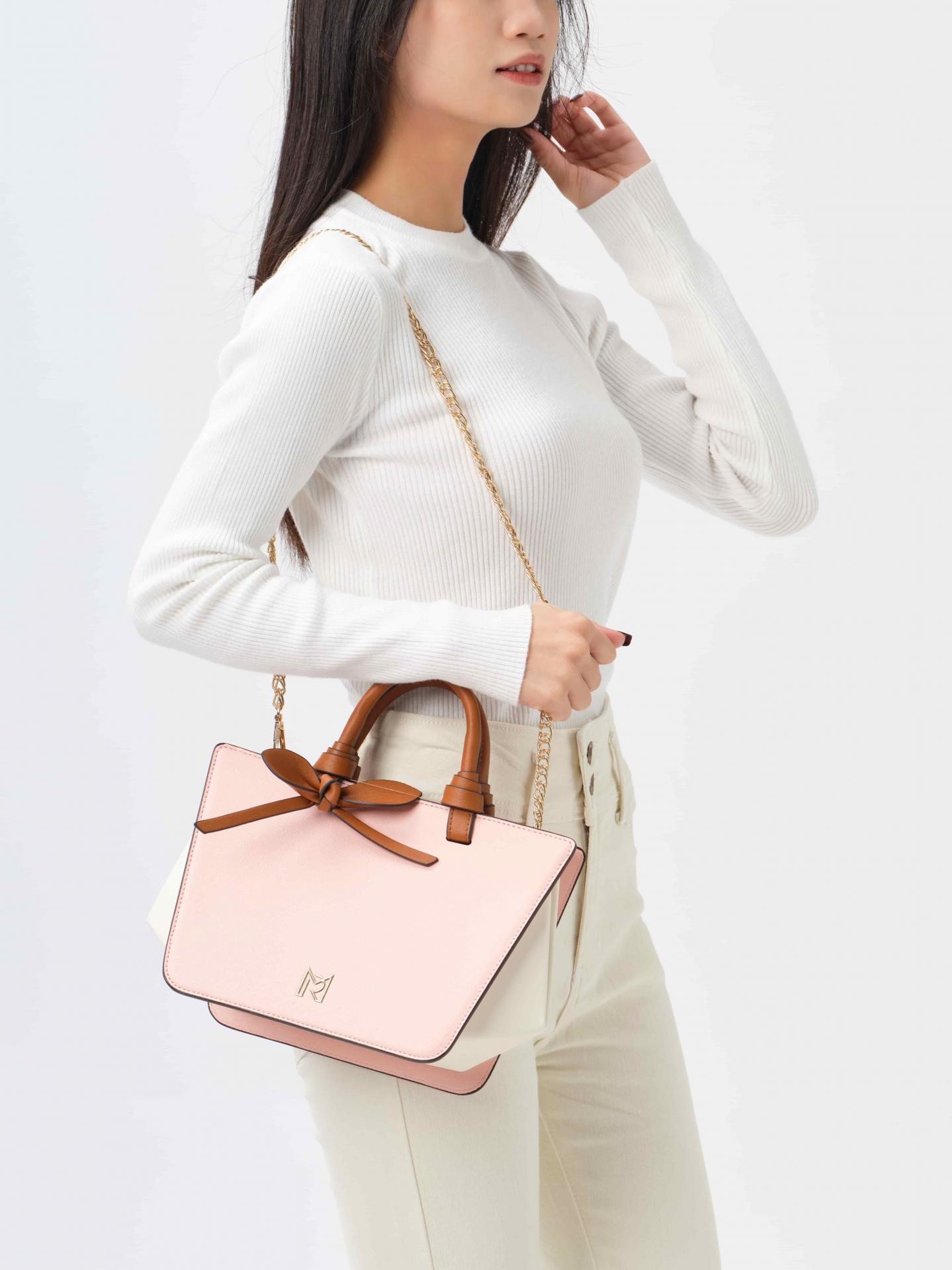 Bolso trapezoidal rosa con correa beige y detalles dorados elegantes