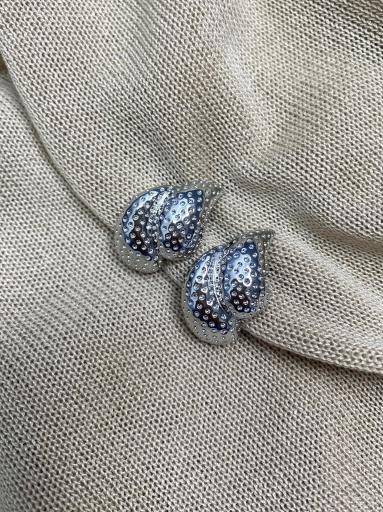 Mujer con pendientes de doble gota plateados y textura de puntos [3]