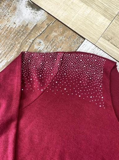 Detalle de brillos plateados en el hombro del jersey granate [1]