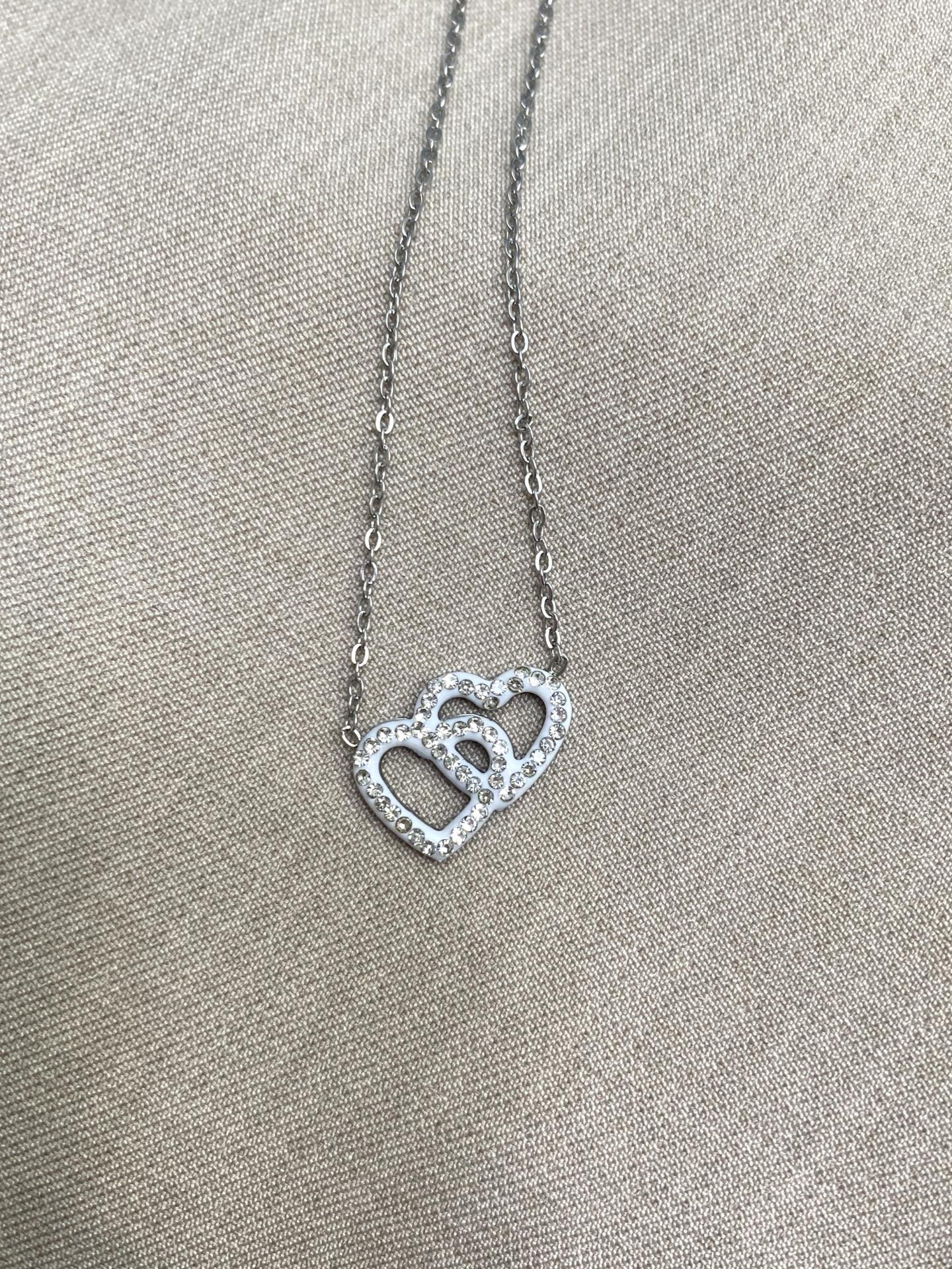 Collar de acero plateado con corazón doble entrelazado y pedrería