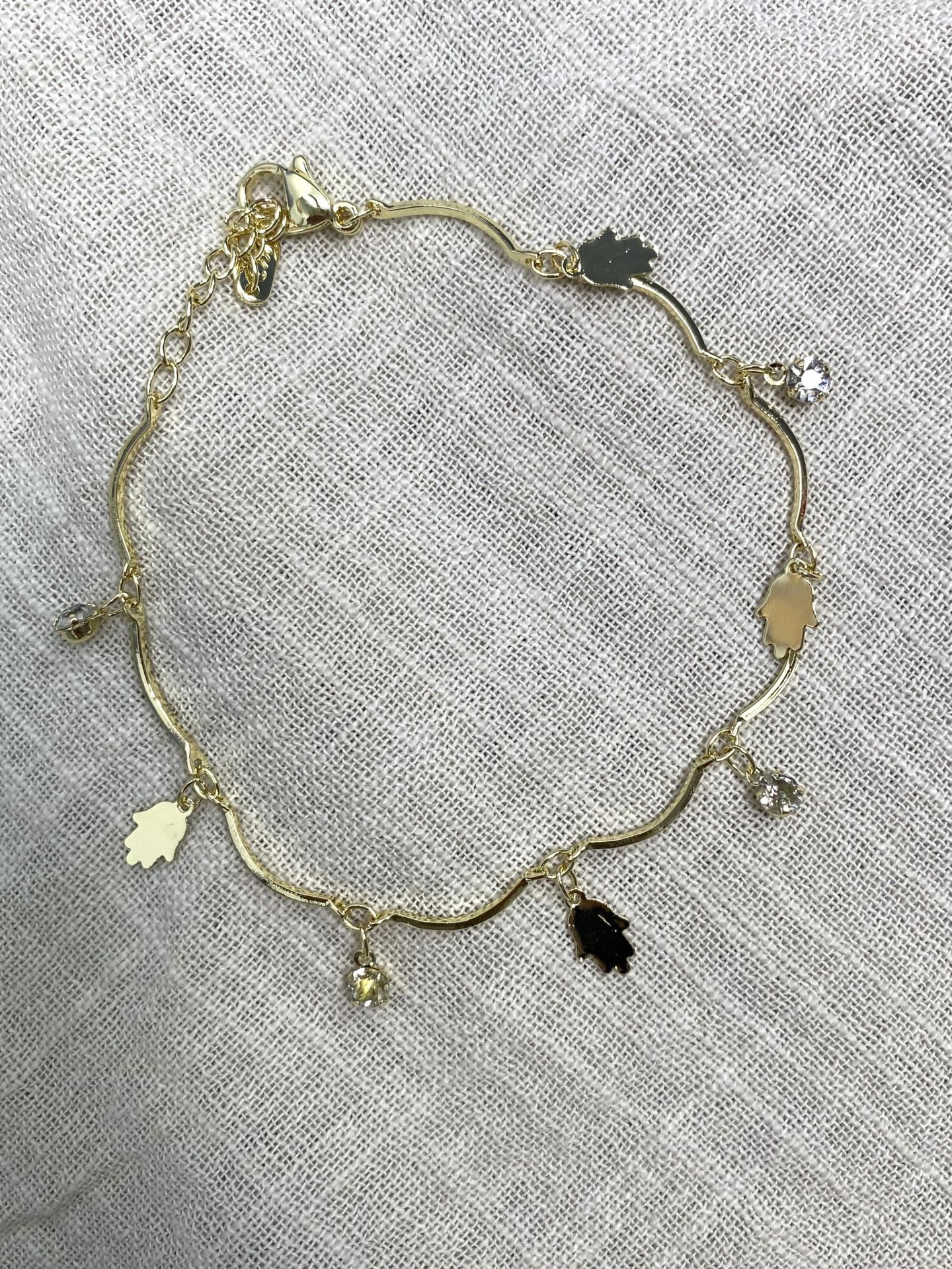 Pulsera dorada con colgantes de Mano de Fátima y brillos