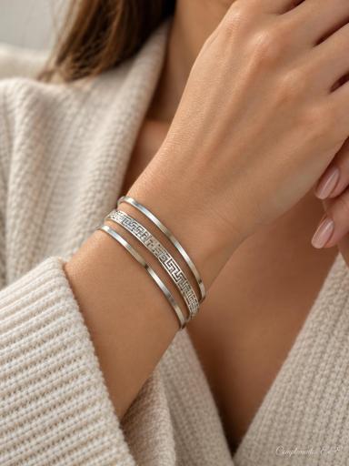 Set de tres pulseras de aro plateadas con dos diseños lisos y una pulsera grabada [1]