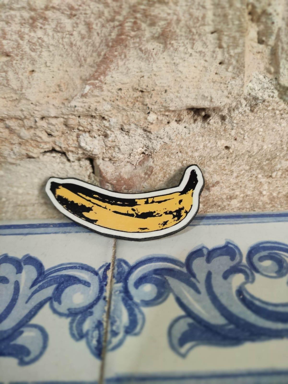 broche-con-forma-de-plátano-sobre-una-pared-de-piedra