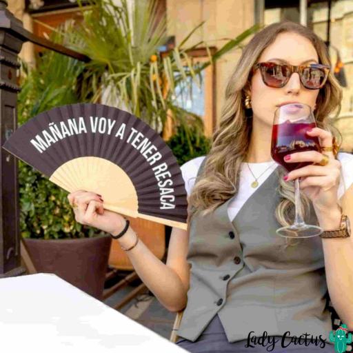 Abanico abierto refrescando el rostro de una persona en un día caluroso de verano en España. [3]
