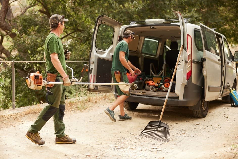 Trabajadores con desbrozadoras profesionales de Jardinería Tecnihabitat se disponen a desbrozar un terreno