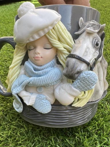 Taza de café en porcelana con niña y su caballo